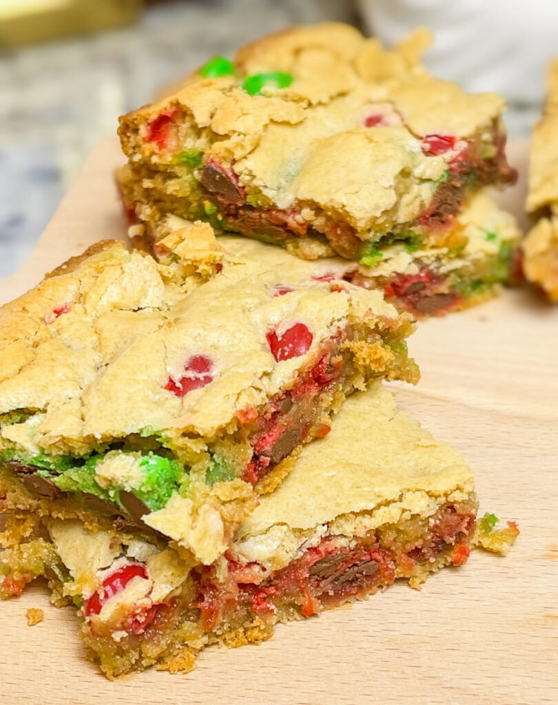 M&M Christmas Cookie Bars are the ultimate holiday treat, combining all the festive fun of Christmas cookies with the ease of a one-pan dessert. These bars are soft, chewy, and bursting with colorful red and green M&M candies. These cookie bars are made with a buttery, golden cookie base and plenty of chocolatey M&M's, these bars are perfect for holiday parties, cookie exchanges, or a cozy night at home with a cup of hot cocoa. Whether you’re baking with kids or whipping up a quick treat for a crowd, these cookie bars are a festive, fuss-free way to spread holiday cheer!