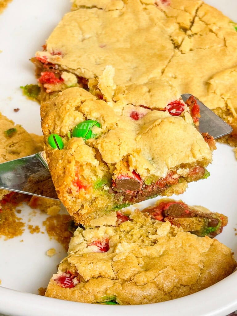 M&M Christmas Cookie Bars are the ultimate holiday treat, combining all the festive fun of Christmas cookies with the ease of a one-pan dessert. These bars are soft, chewy, and bursting with colorful red and green M&M candies.

These cookie bars are made with a buttery, golden cookie base and plenty of chocolatey M&M's, these bars are perfect for holiday parties, cookie exchanges, or a cozy night at home with a cup of hot cocoa. 

Whether you’re baking with kids or whipping up a quick treat for a crowd, these cookie bars are a festive, fuss-free way to spread holiday cheer!