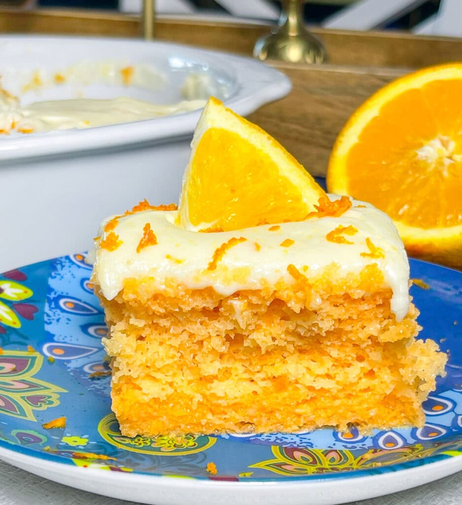 Orange Creamsicle Poke Cake tastes just like the ice cream treat you remember- a bright orange tang along with a creamy vanilla finish. This cake starts with an orange boxed cake mix, studded with creamy orange Jell-o and finished with a citrus orange cream cheese frosting. You'll want to start bringing this dessert everywhere!