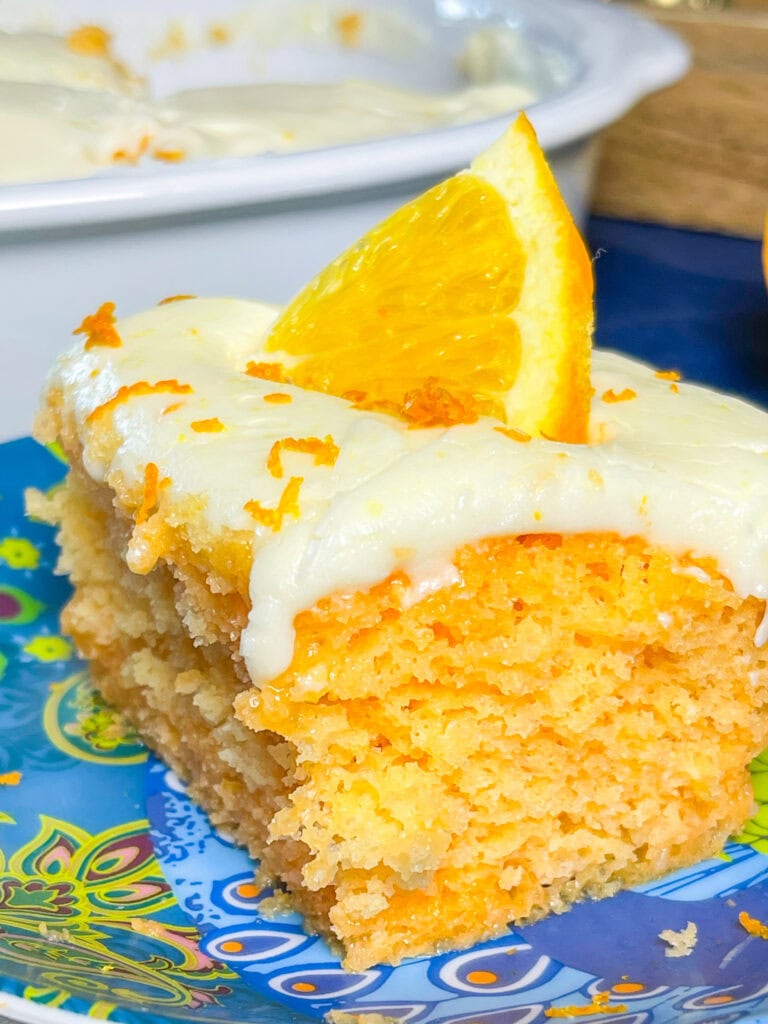 Orange Creamsicle Poke Cake tastes just like the ice cream treat you remember- a bright orange tang along with a creamy vanilla finish. This cake starts with an orange boxed cake mix, studded with creamy orange Jell-o and finished with a citrus orange cream cheese frosting. You'll want to start bringing this dessert everywhere!