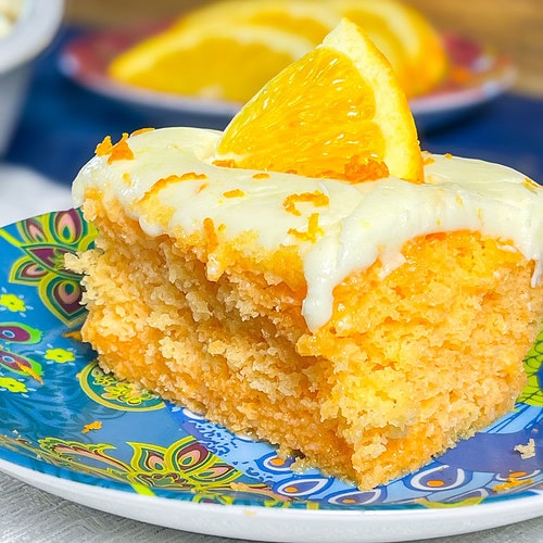 Orange Creamsicle Poke Cake tastes just like the ice cream treat you remember- a bright orange tang along with a creamy vanilla finish. This cake starts with an orange boxed cake mix, studded with creamy orange Jell-o and finished with a citrus orange cream cheese frosting. You'll want to start bringing this dessert everywhere!