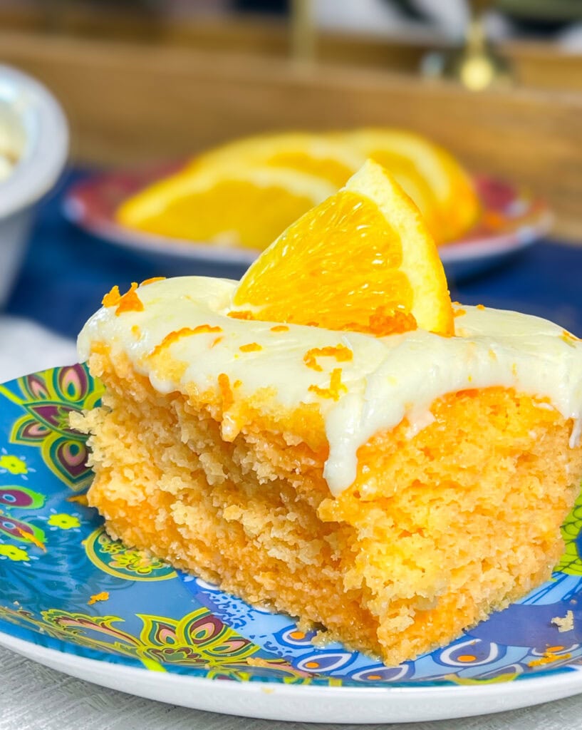 Orange Creamsicle Poke Cake tastes just like the ice cream treat you remember- a bright orange tang along with a creamy vanilla finish. This cake starts with an orange boxed cake mix, studded with creamy orange Jell-o and finished with a citrus orange cream cheese frosting. You'll want to start bringing this dessert everywhere! 