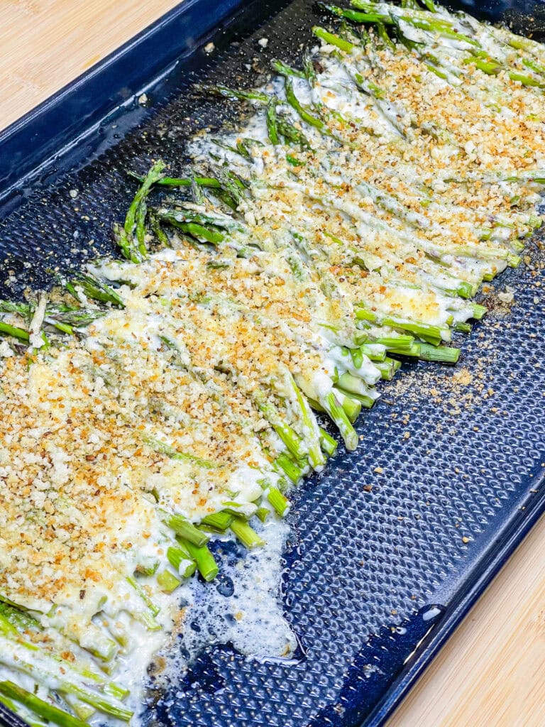 Roasted Mayonnaise and Parmesan Asparagus sounds weird- I know, but I promise it's an amazing side dish! Tender asparagus is coated in mayonnaise and Parmesan cheese, roasted, and then topped with toasted herbed breadcrumbs for crunch. Completely out of the ordinary and totally delicious!