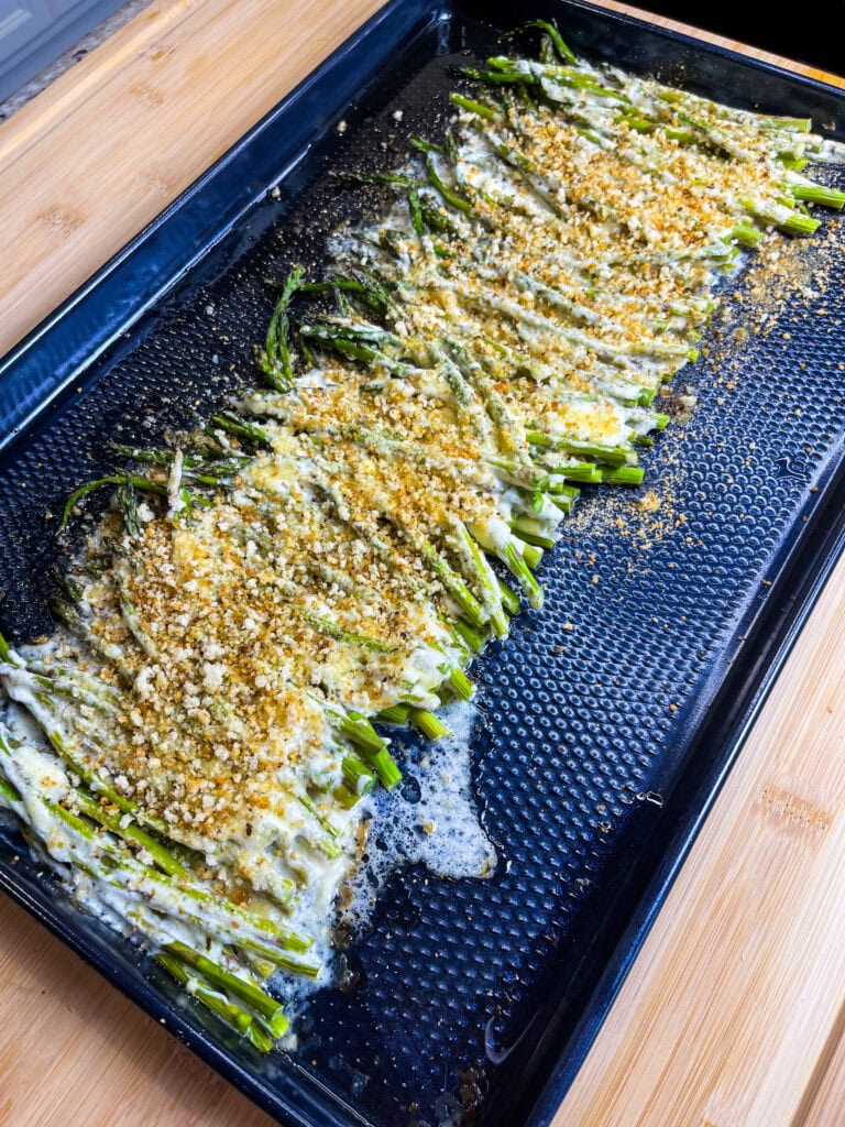 Roasted Mayonnaise and Parmesan Asparagus sounds weird- I know, but I promise it's an amazing side dish! Tender asparagus is coated in mayonnaise and Parmesan cheese, roasted, and then topped with toasted herbed breadcrumbs for crunch. Completely out of the ordinary and totally delicious!