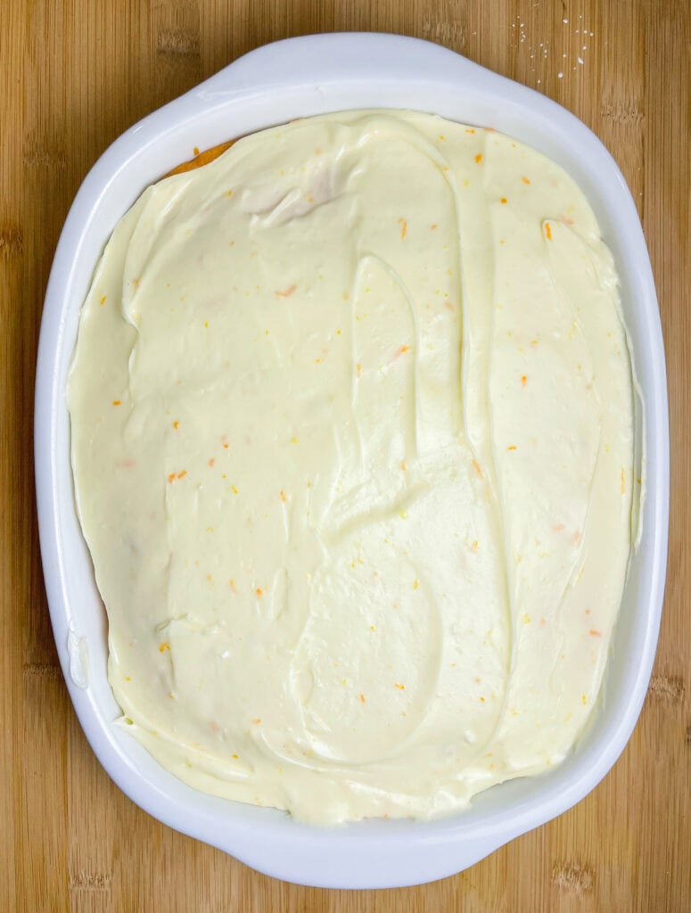 Orange Creamsicle Poke Cake tastes just like the ice cream treat you remember- a bright orange tang along with a creamy vanilla finish. This cake starts with an orange boxed cake mix, studded with creamy orange Jell-o and finished with a citrus orange cream cheese frosting. You'll want to start bringing this dessert everywhere!